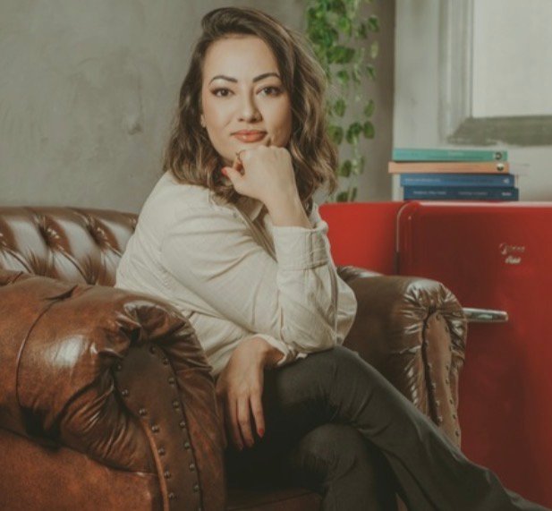 Amanda Yuri sentada em uma poltrona de couro em seu consultório