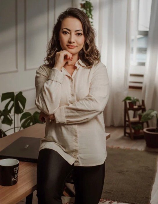 Amanda Yuri em pé no ambiente do seu consultório